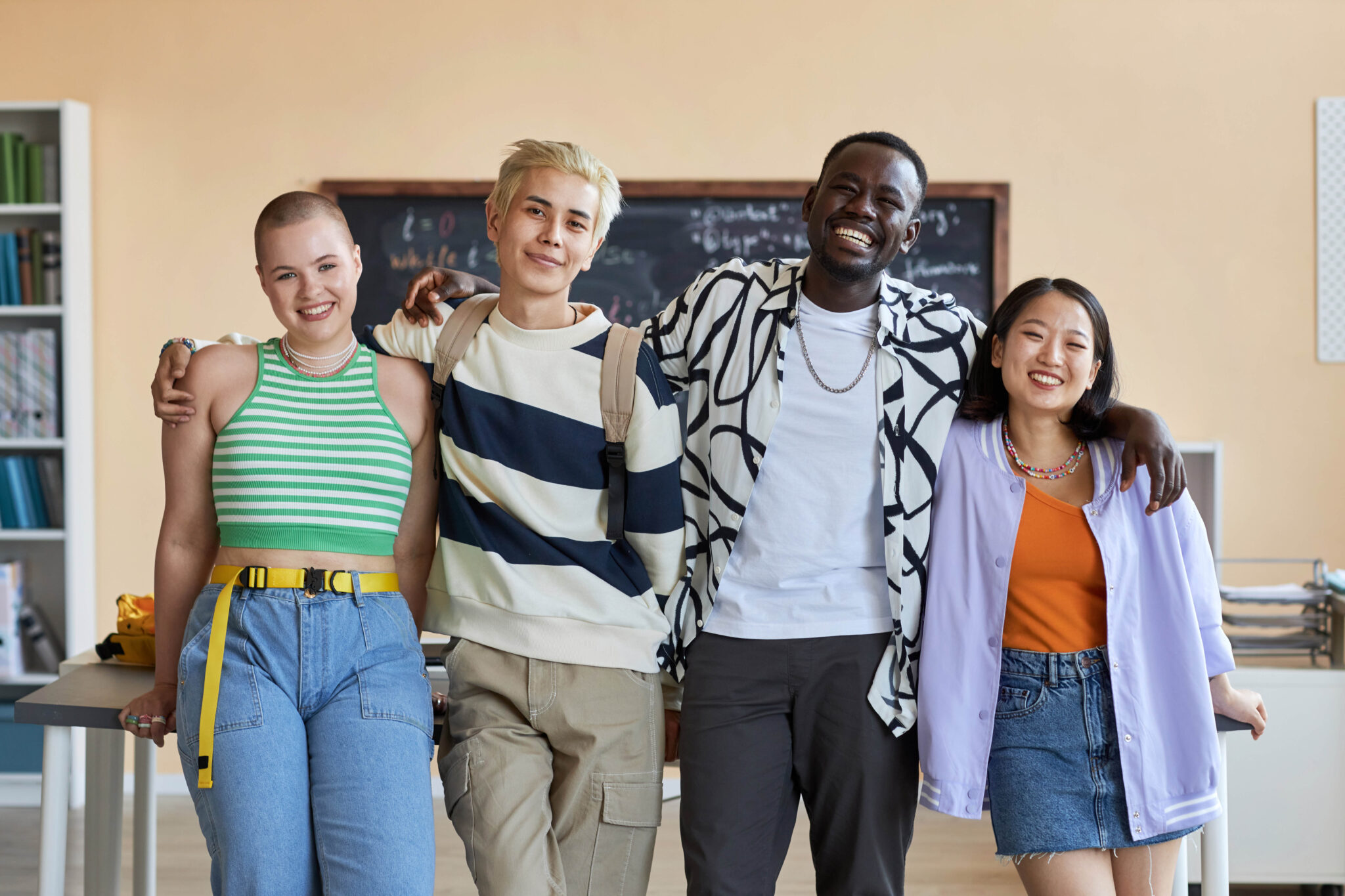 A team of cheerful friendly learners of high school standing together and smiling
